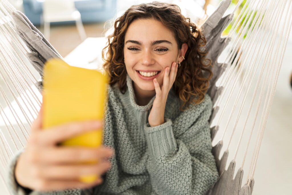 Pretty woman making video call with smartphone, at home
